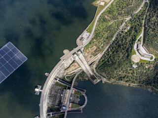 Aerial view of Alqueva Dam at full capacity, with floating solar panels on the water. Alentejo, Portugal.
