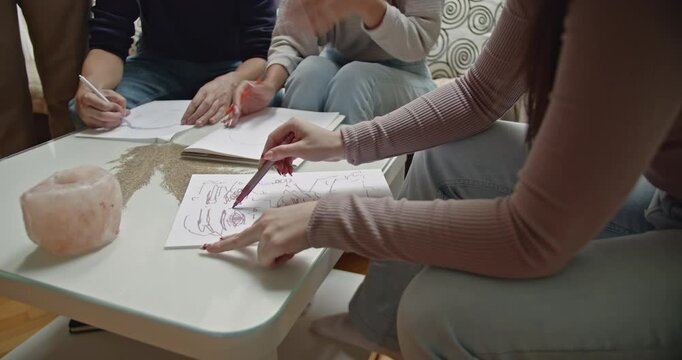 Students learning to draw during a private art class in their professor's home. They practice sketching and improve their drawing techniques.