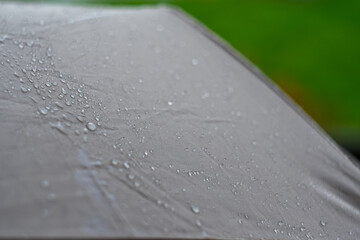 Close-up of rain-drenched umbrella surface with water droplets