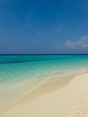 Ocean and sandy beach on a tropical island. Maldivian landscape