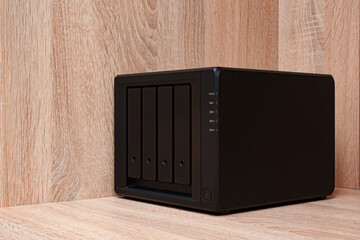 NAS server. Network storage. Device for backing up important information on a brown shelf. Place...