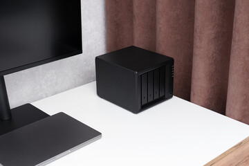 Network storage. NAS server. Device for backing up important information on a white desktop near a...