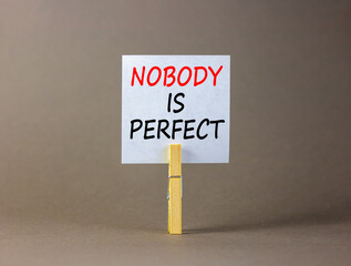 Nobody is perfect symbol. Concept words Nobody is perfect on beautiful white paper on clothespin. Beautiful grey background. Business motivational lifestyle and nobody is perfect concept. Copy space