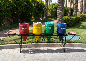 Color-coded recycle bins in Egypt hotel resort dedicated to separate waste collection for plastic glass metal and paper highlighting recycling and environmental responsibility. Environmental concept.