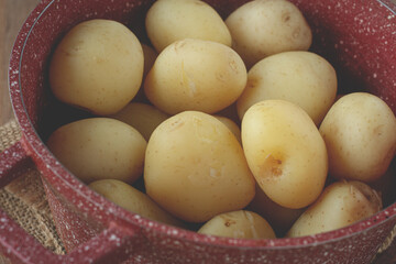 boiled new potatoes, in a pot, on a rustic table, natural light, no people,