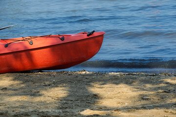 Red canoe on the beach by the lake