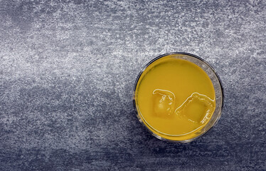 Refreshing summer beverage in glass with ice on textured background for culinary and food design