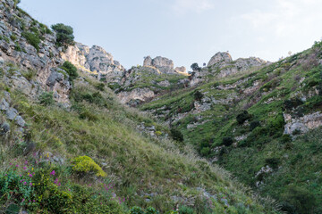 A mountain in Campania, Italy, on the Tyrrhenian Sea, seen from below. White cliffs, some trees and grass.
