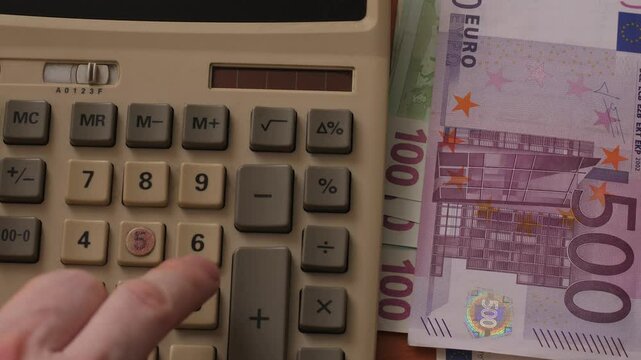 Close-up calculator and euro banknotes of different denominations, concept income and expense calculation, budget planning