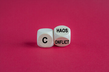 Conflict and chaos symbol. Wooden cubes form the expression from Conflict to Chaos. Beautiful red background. Business Conflict and Chaos concept.