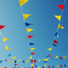 Colorful Triangle Flags Hanging Against Blue Sky