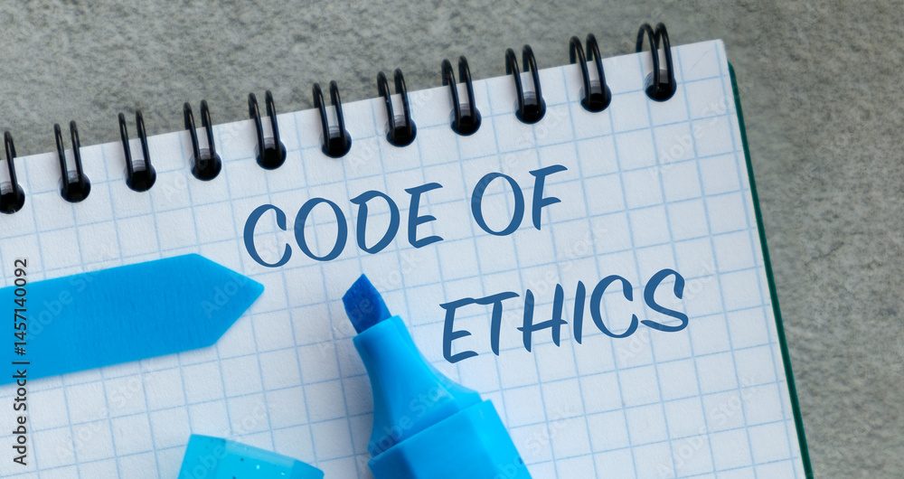 Poster a blue marker is on a spiral notebook with the word code of ethics written in