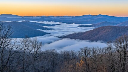 A beautiful mountain landscape featuring fog in a valley at dawn