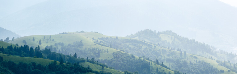 Heavy rain over the green summer, foggy mountain hills in the Carpathian Mountains. Rainy weather in the mountains. Foggy perspective.