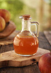 Apple cider vinegar in a glass bottle on a table outdoors