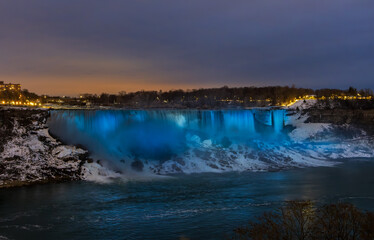 Niagara Falls by night with projected beautiful colours illuminating  the waterfall, Ontario, Canada.