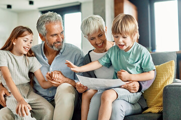 grandchild family child grandparent grandfather happy together grandmother girl senior boy read...