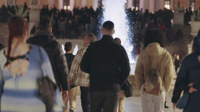  Lively scene at Syntagma Square in Athens, Greece with demonstrant people gather around a beautifully illuminated fountain during the night