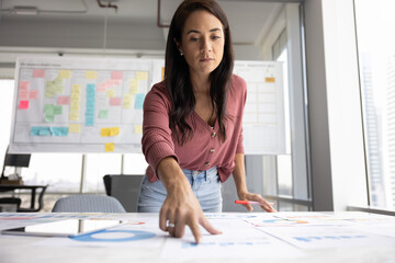 Project review. Focused young female business analyst operations manager entrepreneur stand by work...
