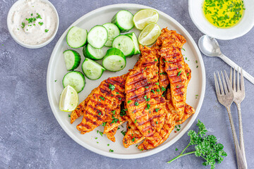 Grilled Chicken Breast Tenders with Lemon and Cucumber Directly Above Photo
