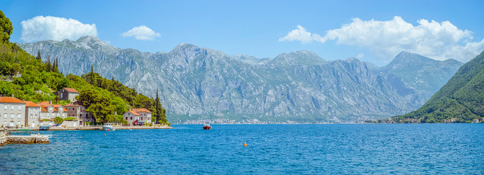 Coastal village nestled against mountains and blue water, Dobrota Beach, Kotor, Montenegro