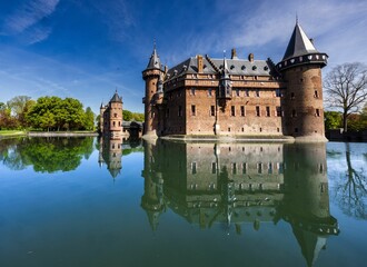 Obraz premium De Haar Castle reflecting in a tranquil lake.