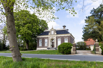 Scenic view of a traditional large farm house (Herenboer) surrounded by old trees in Oldambt Groningen The Netherlands.