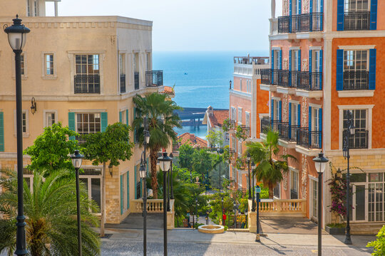Fototapeta Mediterranean style coastal town with colorful buildings, street and sea view in tropical coastal Sunset Town, Phu Quoc island, Vietnam. Italian architecture in Asia. Travel and touristic landmark