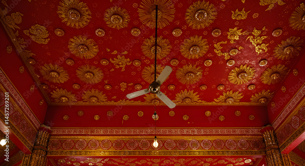Poster elaborate red and gold ceiling intricate carvings decorative patterns and hanging fan creating a ric