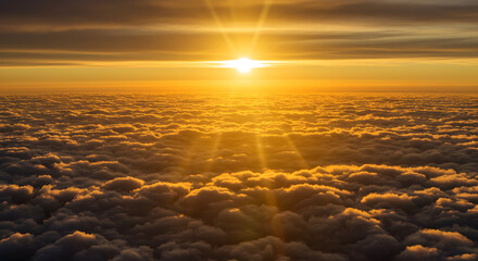 Obraz premium Golden Sunset Illuminating Fluffy White Clouds from Above Scenic Aerial View