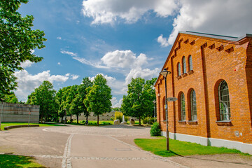 Red Brick Building and Tree-Lined Street in Ingolstadt on Sunny Day