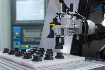 Close up industrial automation gripping robot working with metalwork on CNC machine on smart manufacturing and right copy space, industry 4.0 and modern technology