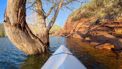 spring kayaking or canoeing in a sandstone canyon of the Horsetooth Reservoir near Fort Collins, Colorado - POV paddler perspective