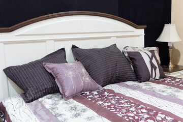 Relaxing bedroom detail of pillows on bed and side lamp