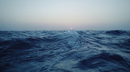 The ocean surface and the distant sun at the horizon line
