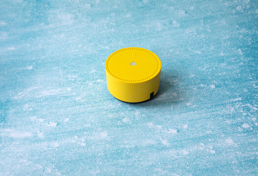 a yellow wireless smart speacker on the blue background