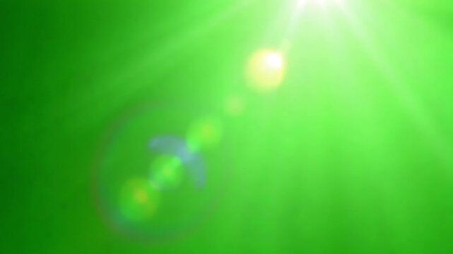 Green screen background with bright sunlight rays ideal for compositing and visual effects projects