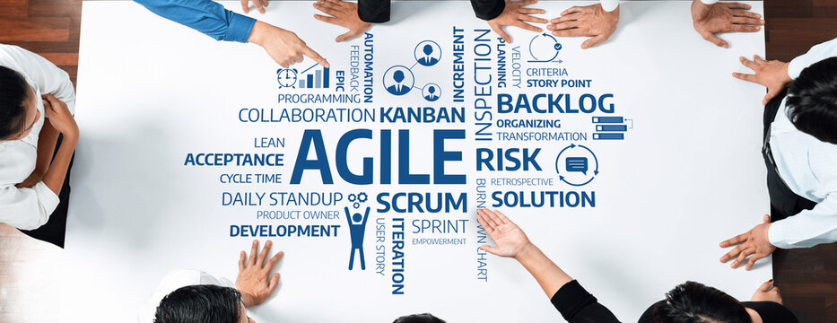 A group of professionals collaborating on agile concepts with keywords displayed on a table, showcasing the importance of strategy, risk management, and project efficiency. Amity