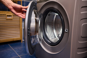 A contemporary modern washing machine with its door open, showcasing laundry inside