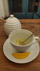 Inviting cup of herbal tea with fresh lemon slice and honey pot on rustic wooden table creating a cozy atmosphere for relaxation and enjoyment