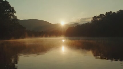 Obraz premium The sun setting over the lake casting golden light across the landscape