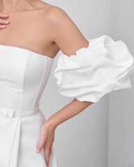 Blonde woman in elegant bridal dress posing in bright interior with archway detail