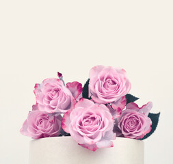 Pink rose flower bouquet on podium. Light beige background. Minimal neutral still life.