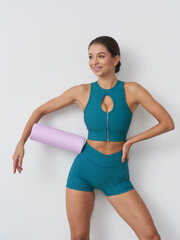 Sporty woman practicing fitness with a foam roller in a bright interior space