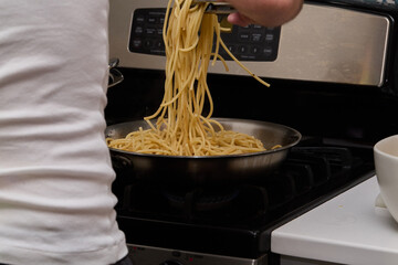 Cooking Spaghetti Pasta on Stove with Sauce Preparation
