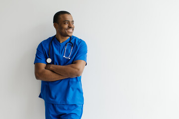 Smiling Young Black Male Doctor In Uniform Posing Over White Background, African American Physician...