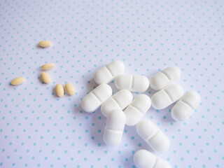 White and yellow tablets on a light background in a dot. Medicines for the treatment of various...