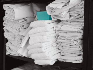 close-up of a stocked linen cart or organized shelving with clean white sheets and towels. isolated color design element © Caroline
