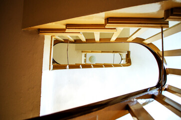 Looking Down a Modern Wooden Spiral Staircase Inside a Building Showing Architectural Design and...