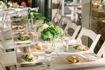 Elegant dining setup at a summer event with fresh salads and natural decor